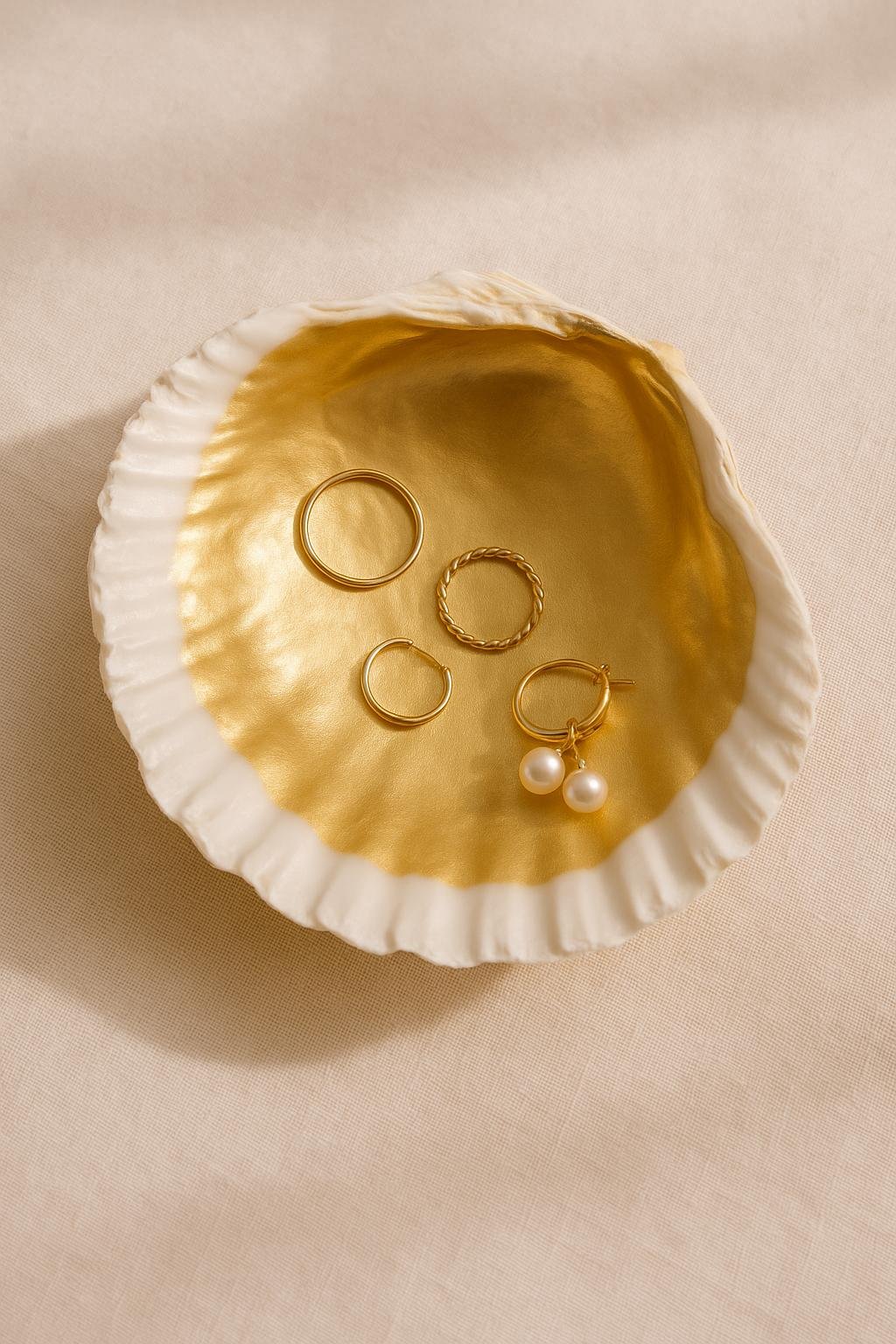 Seashell lined with gold foil and sealed with Mod Podge, used as a handmade jewelry dish