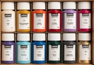 Ceramic mug painting supplies including markers and colorful craft paint