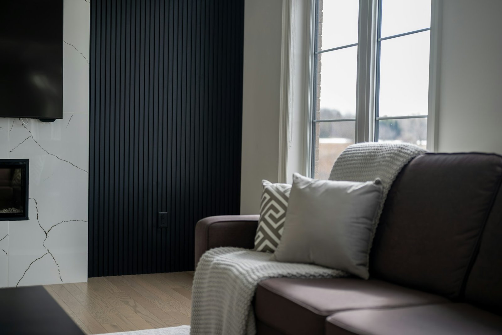 Modern brown leather sofa styled with warm wood, soft textiles and natural light