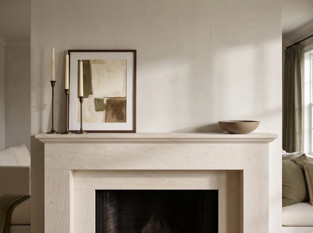 Asymmetrical fireplace mantel with three ivory LED tapers and framed artwork at one end, balanced by a low decorative bowl at the other.