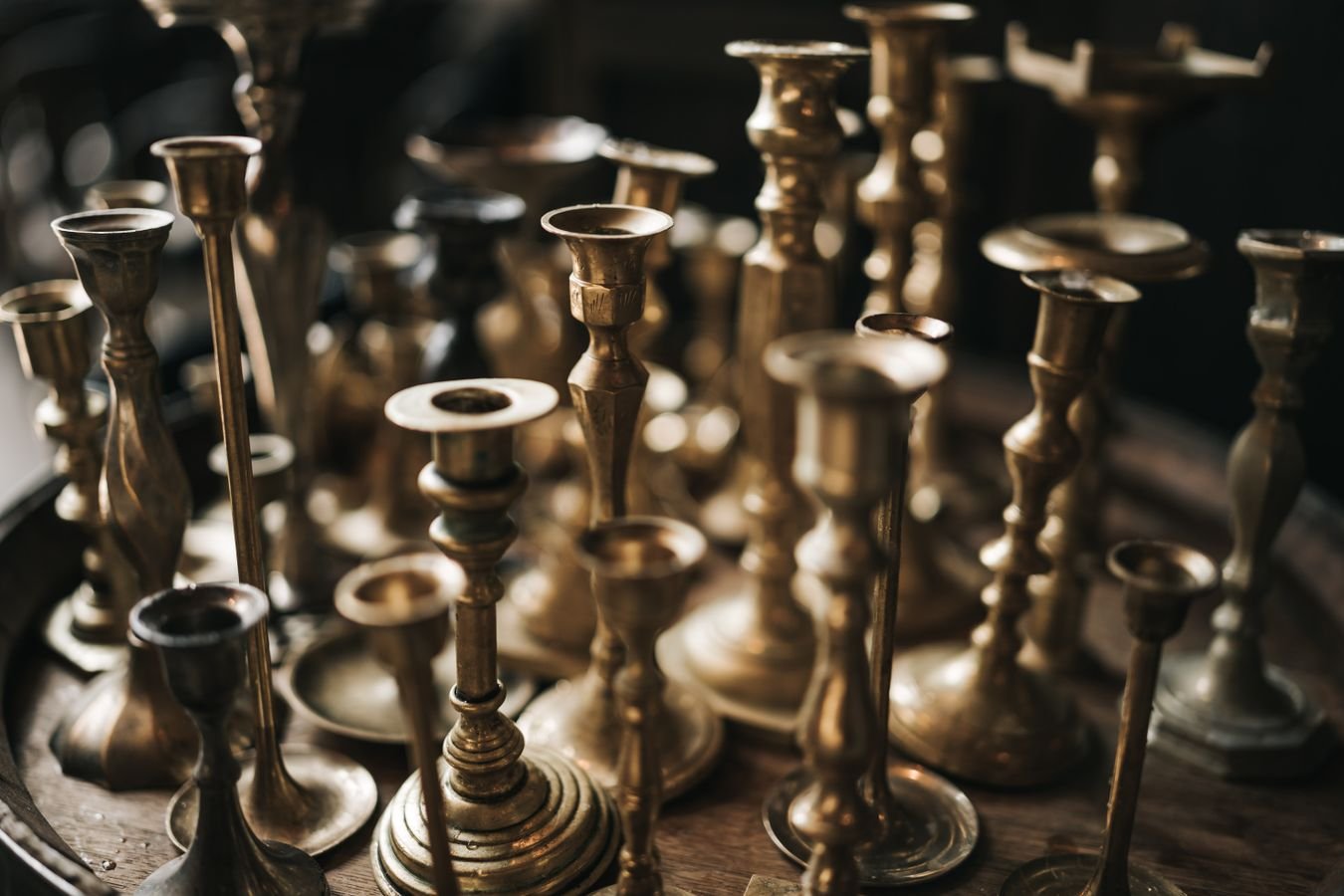 An assortment of old brass and copper candle holders with visible aged metal finishes